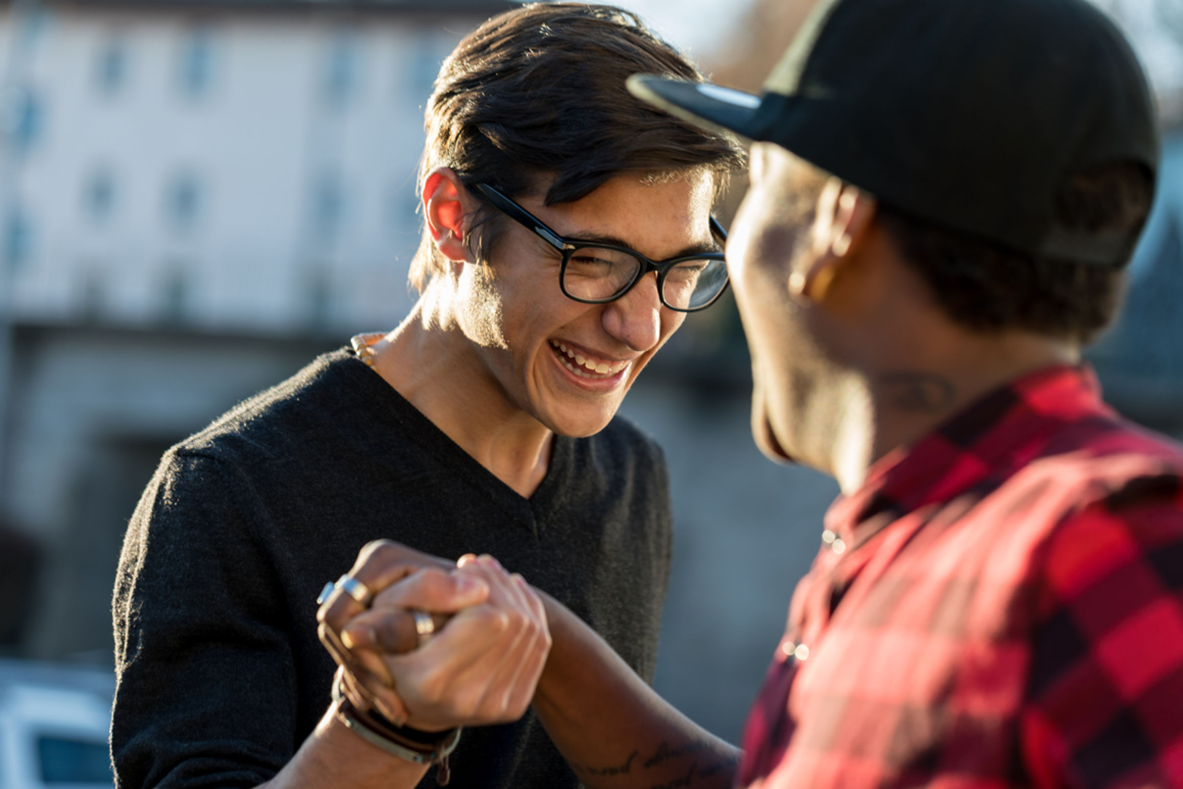 two guys greeting each other smiling, hands grasped
